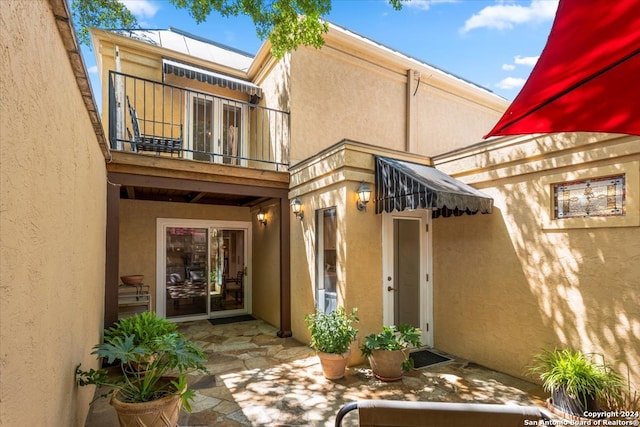 rear view of house with a balcony and a patio area