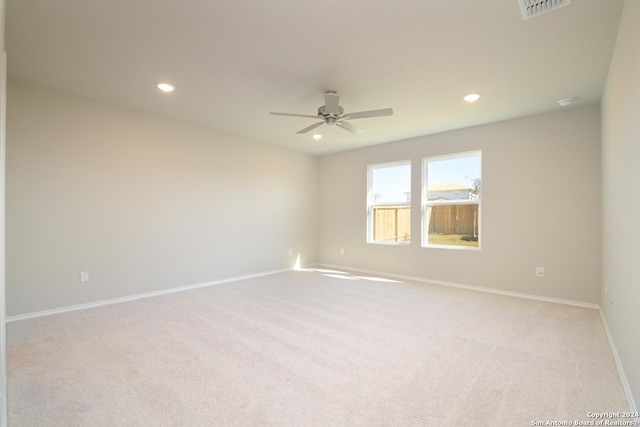 carpeted spare room featuring ceiling fan