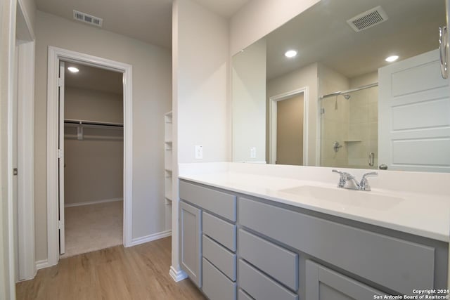 bathroom with vanity, a shower with shower door, and hardwood / wood-style flooring