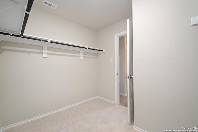 walk in closet featuring light colored carpet