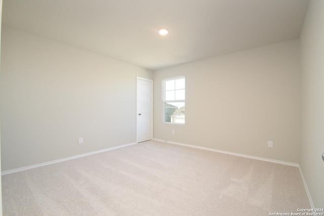 unfurnished room featuring light carpet