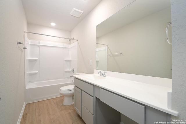 full bathroom featuring hardwood / wood-style flooring, toilet, vanity, and  shower combination