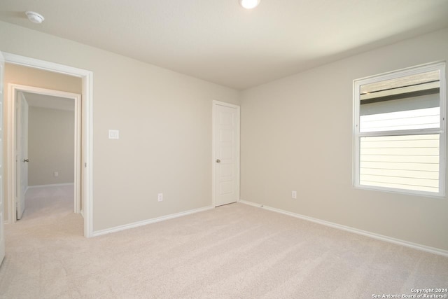 unfurnished room featuring light colored carpet