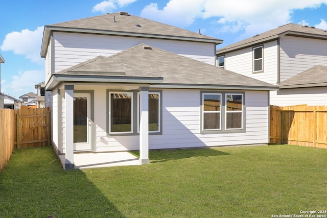 back of property with a patio and a lawn