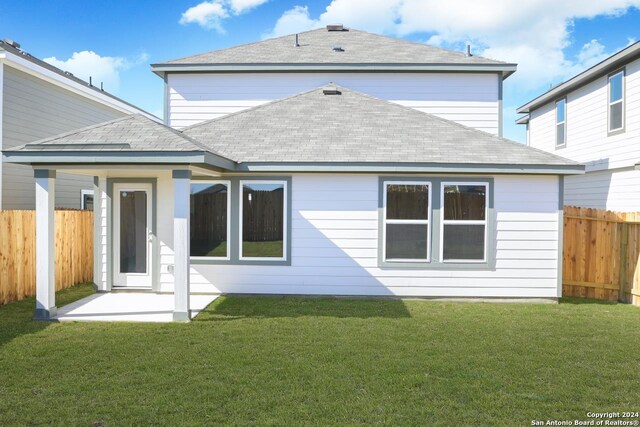 rear view of house with a patio area and a lawn