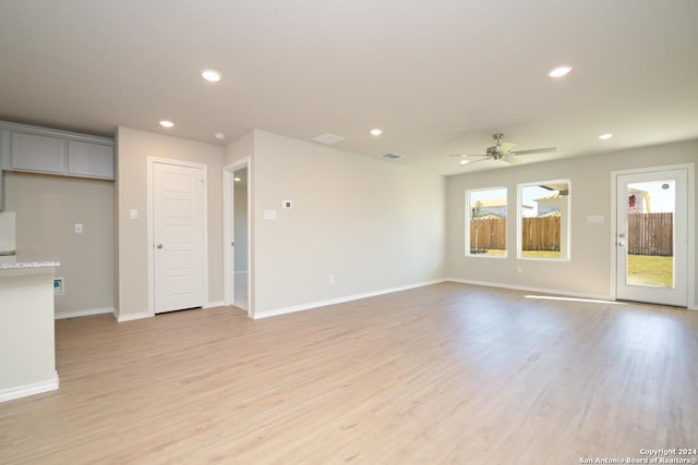 unfurnished living room featuring ceiling fan and light hardwood / wood-style floors