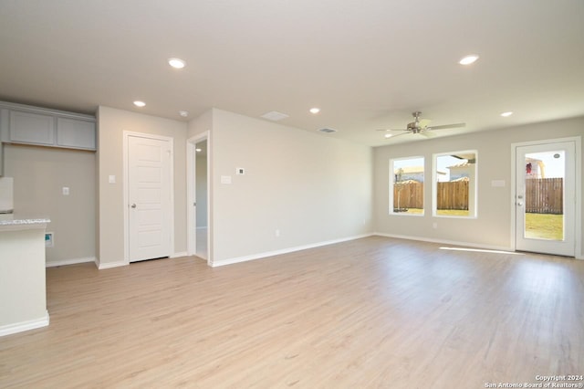 unfurnished living room featuring light hardwood / wood-style flooring and ceiling fan