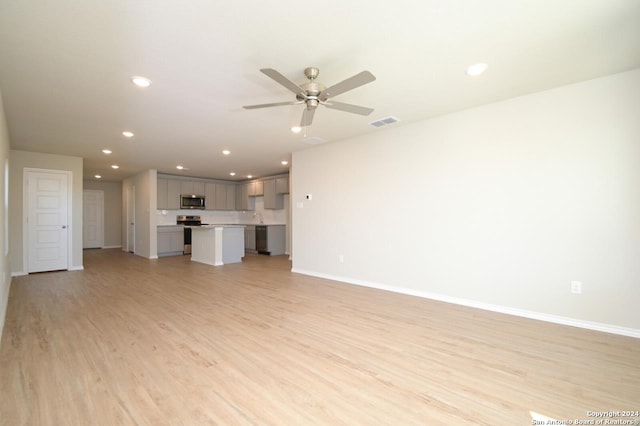 unfurnished living room featuring sink, light wood-type flooring, and ceiling fan