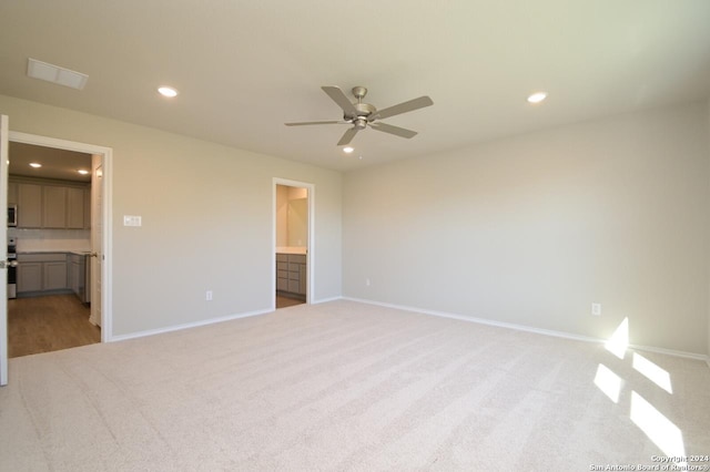 unfurnished bedroom featuring ceiling fan, connected bathroom, and light carpet