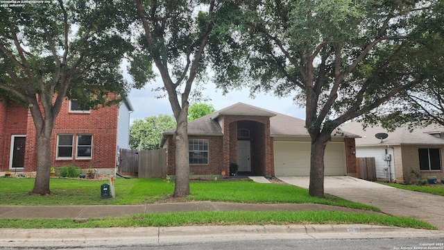 view of front of property with an attached garage, brick siding, fence, concrete driveway, and a front yard