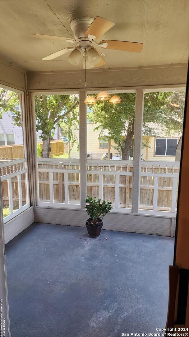 unfurnished sunroom featuring ceiling fan