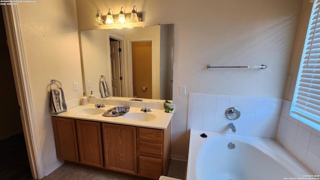 full bathroom with a bath, tile patterned flooring, double vanity, and a sink