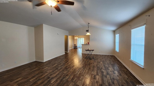 unfurnished living room featuring lofted ceiling, a ceiling fan, baseboards, and dark wood-style flooring