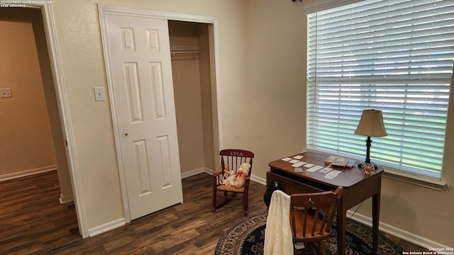 home office with dark wood-type flooring, a wealth of natural light, and baseboards