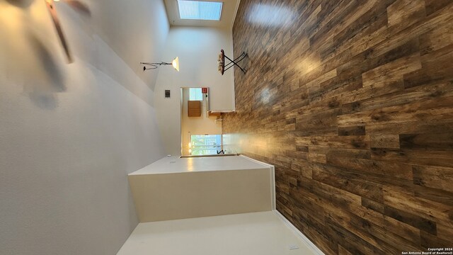 bathroom with wood walls and a skylight