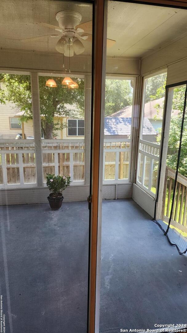 unfurnished sunroom with a ceiling fan