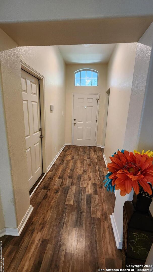 doorway to outside with dark wood-style flooring and baseboards