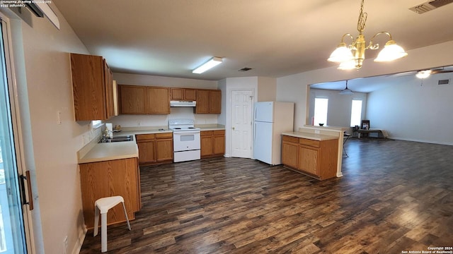 kitchen featuring light countertops, visible vents, a sink, white appliances, and under cabinet range hood