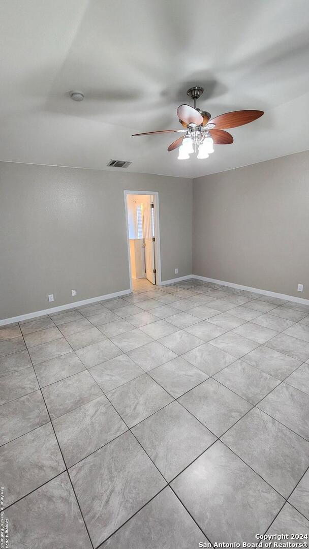 unfurnished room featuring baseboards, visible vents, and a ceiling fan