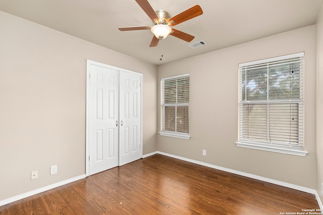 unfurnished bedroom featuring ceiling fan, hardwood / wood-style flooring, and a closet