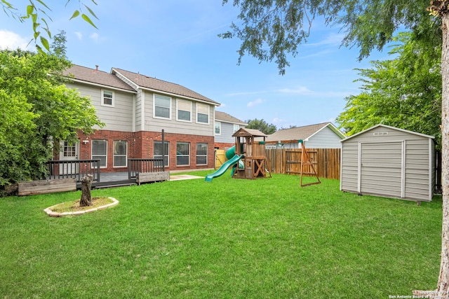 view of yard with a playground, a deck, and a storage shed