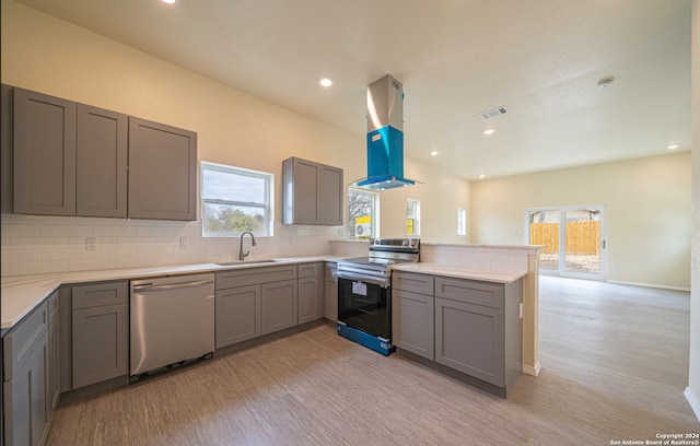 kitchen featuring tasteful backsplash, island range hood, electric range oven, sink, and dishwasher