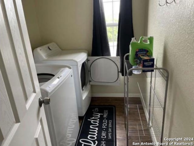 washroom with dark wood-type flooring and separate washer and dryer