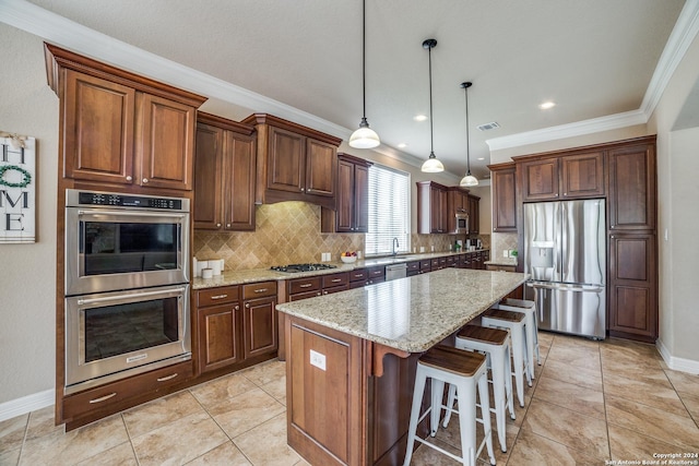 kitchen featuring a breakfast bar area, light stone counters, decorative light fixtures, a kitchen island, and stainless steel appliances