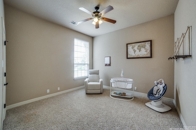 sitting room with ceiling fan and carpet flooring