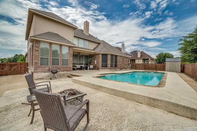 view of swimming pool featuring a storage unit and a patio area