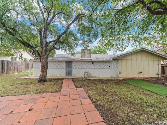 back of property with a patio and a lawn