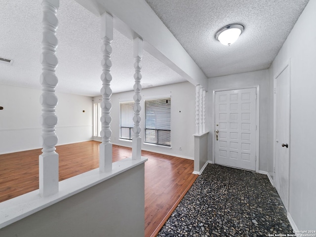 entrance foyer with a textured ceiling and hardwood / wood-style flooring