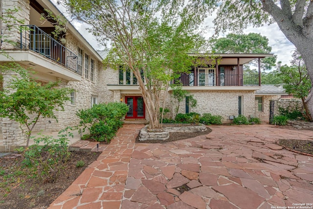 exterior space with a patio, french doors, and a balcony