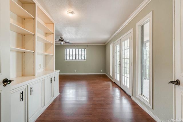 interior space with dark wood-type flooring, a textured ceiling, ceiling fan, and ornamental molding