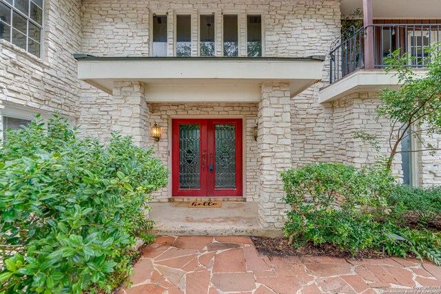 property entrance with a balcony and french doors