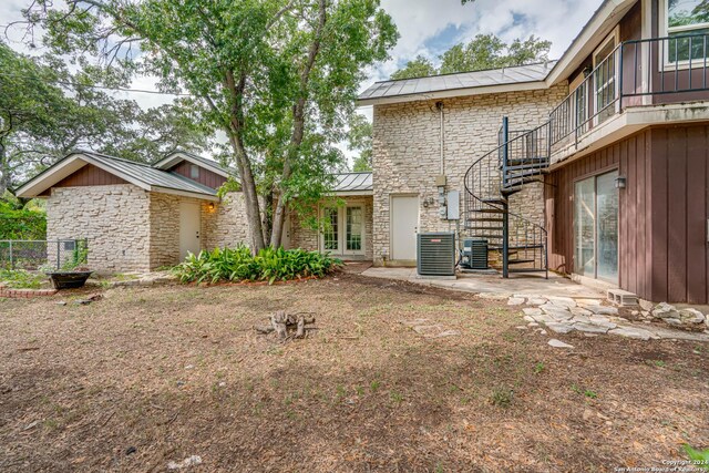 back of property featuring cooling unit and french doors