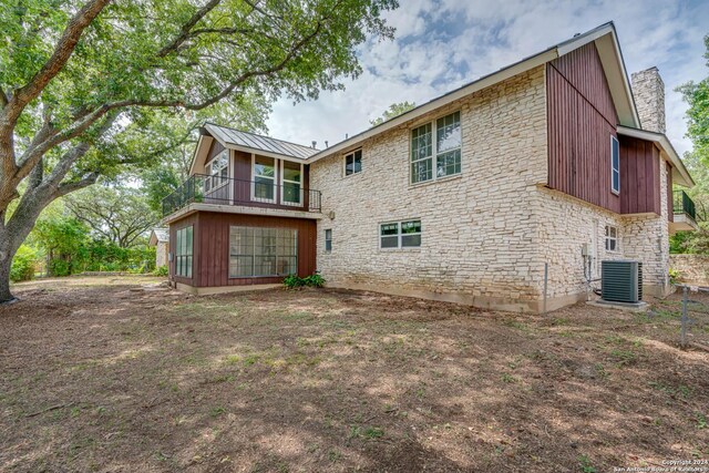 back of property with a balcony and central AC