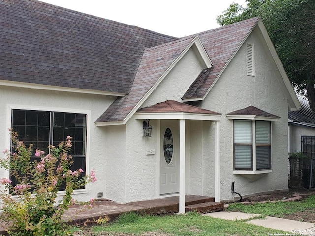 view of front of home featuring a shingled roof and stucco siding