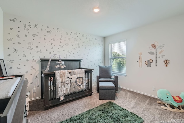 bedroom featuring a nursery area and carpet