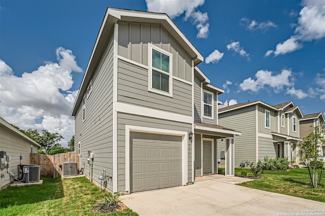 view of front facade with central AC, a garage, and a front yard