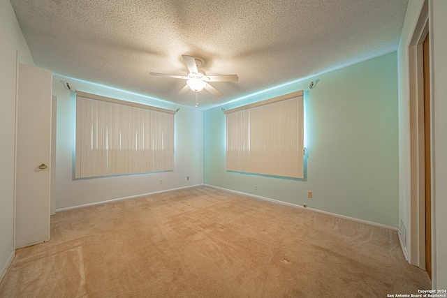 carpeted empty room featuring a textured ceiling and ceiling fan