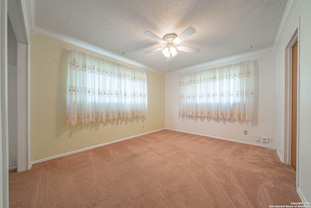 spare room featuring ornamental molding, ceiling fan, a healthy amount of sunlight, and light colored carpet