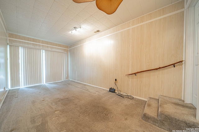 empty room with wood walls and carpet floors