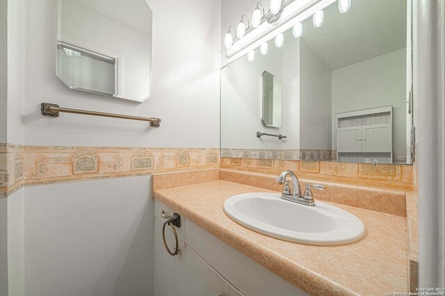 bathroom with vanity and a textured ceiling