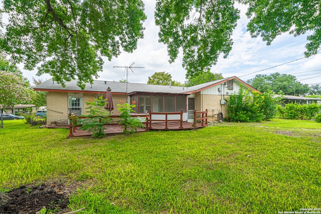 back of house with a sunroom, a wooden deck, and a yard