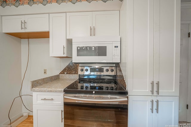 kitchen featuring light hardwood / wood-style floors, white cabinets, and stainless steel range with electric cooktop