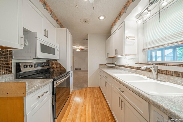 kitchen featuring white cabinetry, ceiling fan, light hardwood / wood-style floors, stainless steel electric range oven, and sink