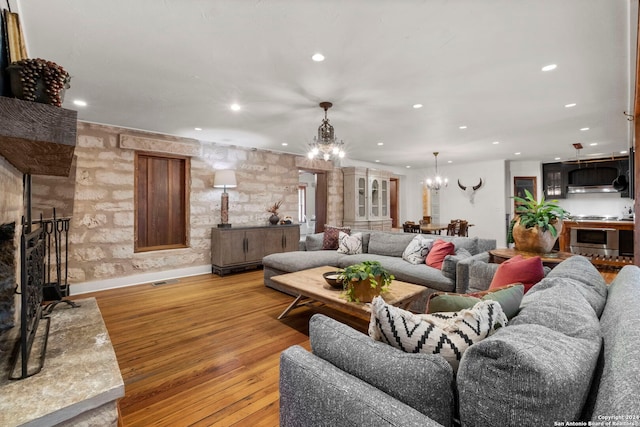 living room with light hardwood / wood-style floors and a notable chandelier