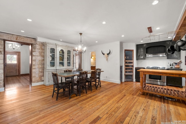 dining room featuring an inviting chandelier, crown molding, and light hardwood / wood-style floors