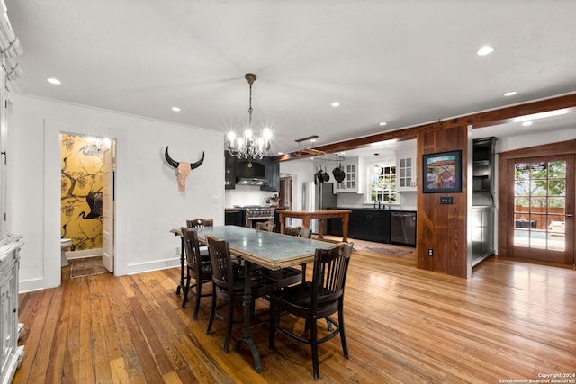 dining space with light hardwood / wood-style floors and a notable chandelier